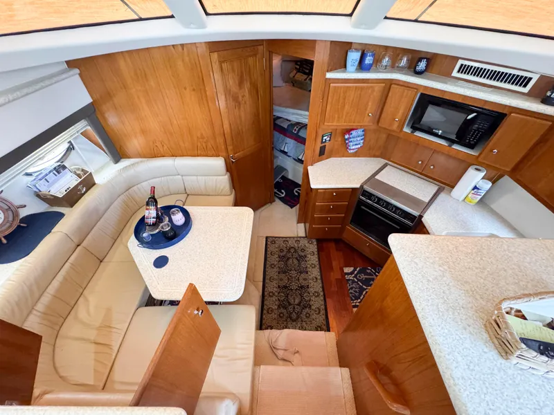 Slide: The Image of 1999 Carver 406 Aft Cabin Motor Yacht interior with kitchen and seating area. - 28