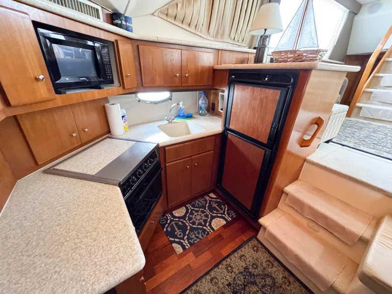 Slide: The Image of 1999 Carver 406 Aft Cabin Motor Yacht kitchen with wood cabinetry and modern appliances. - 31