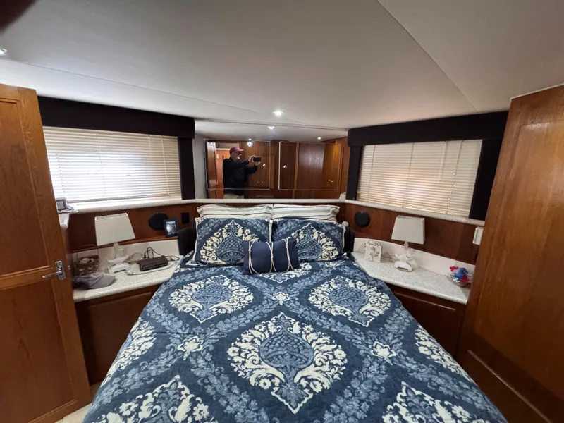 Slide: The Image of 1999 Carver 406 Aft Cabin Motor Yacht bedroom with patterned bedding and wood accents. - 33