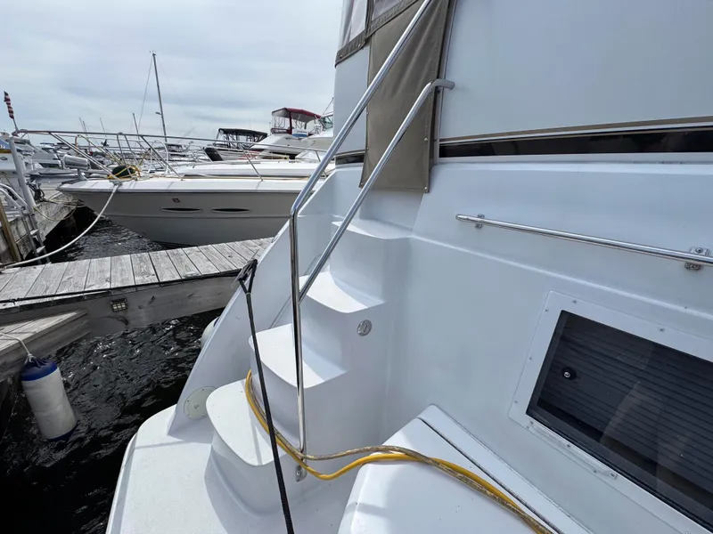Slide: The Image of 1999 Carver 406 Aft Cabin Motor Yacht docked, showing exterior stairs and railing. - 4