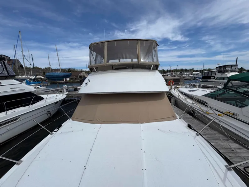 Slide: The Image of 1999 Carver 406 Aft Cabin Motor Yacht docked at marina under blue sky. - 5