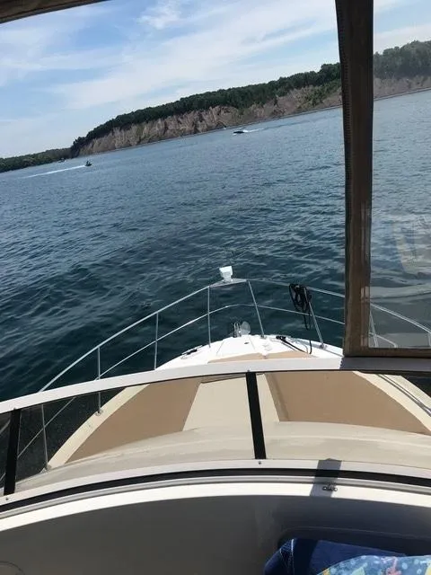 Slide: The Image of 1999 Carver 406 Aft Cabin Motor Yacht cruising on a scenic lake. - 7