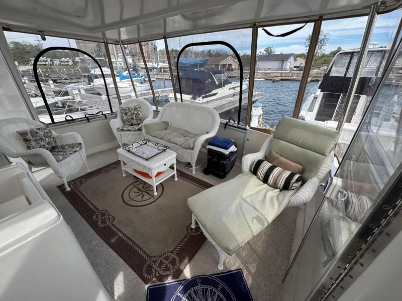 Slide: The Image of 1999 Carver 406 Aft Cabin Motor Yacht interior with cozy seating and marina view. - 9