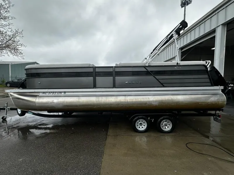 Slide: The Image of 2021 Crest Classic LX 240 SLS pontoon boat on trailer, parked outdoors. - 0
