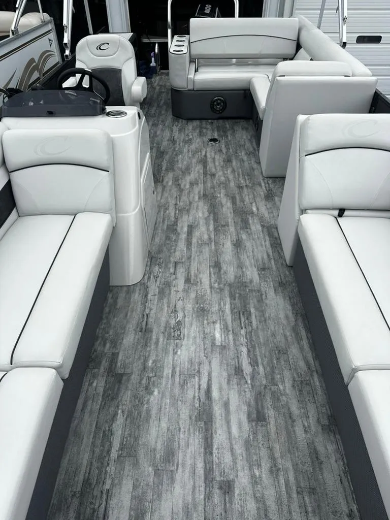Slide: The Image of 2021 Crest Classic LX 240 SLS boat interior with gray flooring and white seating. - 11