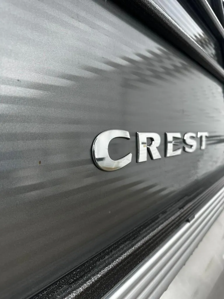 Slide: The Image of 2021 Crest Classic LX 240 SLS boat, close-up of logo on sleek metallic surface. - 12