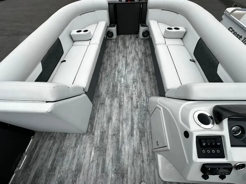 Slide: The Image of 2021 Crest Classic LX 240 SLS boat interior with gray flooring and white seating. - 5
