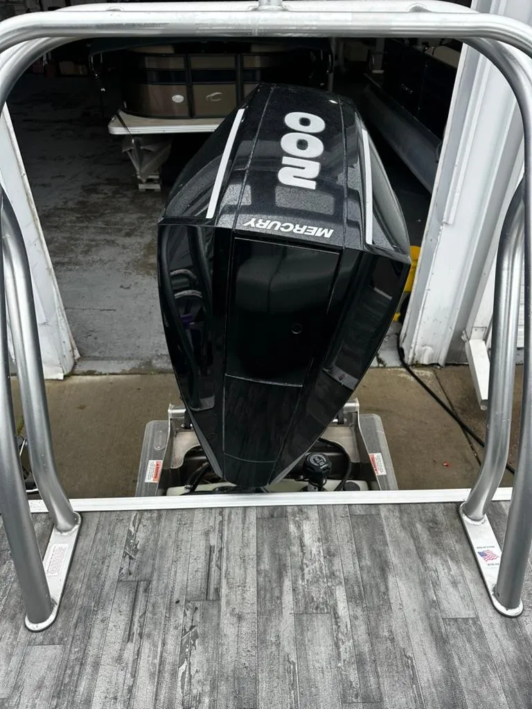 Slide: The Image of Outboard motor on a 2021 Crest Classic LX 240 SLS boat, docked indoors. - 9
