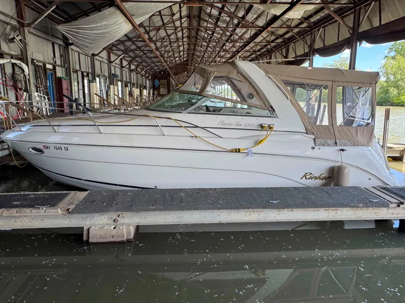 The Image of 2004 Rinker Fiesta Vee 290 boat docked in a covered marina. - 0