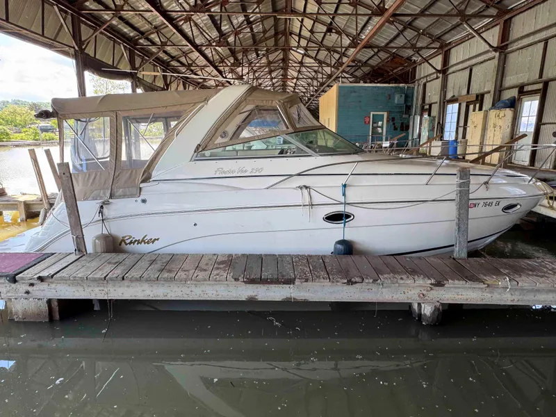 Slide: The Image of 2004 Rinker Fiesta Vee 290 boat docked in a covered marina. - 1