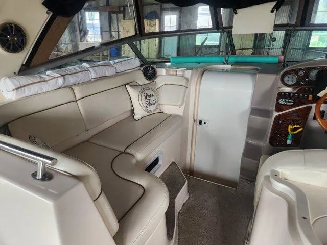 Slide: The Image of 2004 Rinker Fiesta Vee 290 boat interior with beige seating and dashboard. - 11