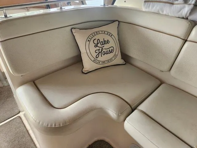 Slide: The Image of 2004 Rinker Fiesta Vee 290 interior with "Lake House" cushion on beige seating. - 13
