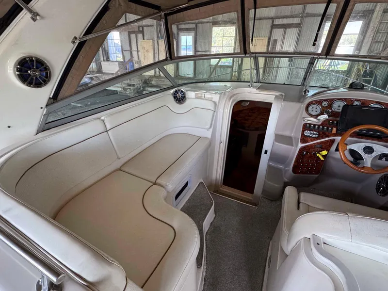 Slide: The Image of 2004 Rinker Fiesta Vee 290 boat interior with white seating and wooden dashboard. - 16