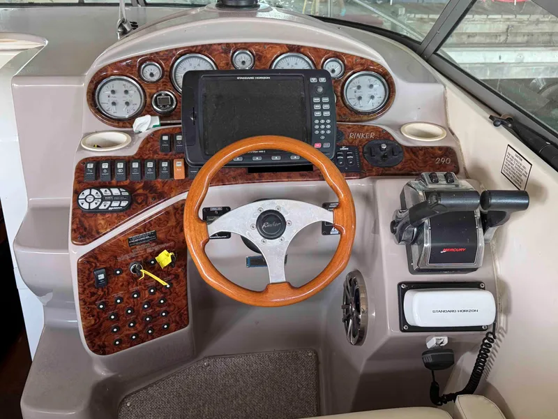 Slide: The Image of 2004 Rinker Fiesta Vee 290 boat dashboard with steering wheel and navigation controls. - 17