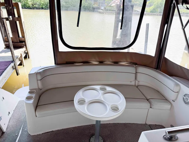 Slide: The Image of 2004 Rinker Fiesta Vee 290 boat interior with curved seating and round table. - 18