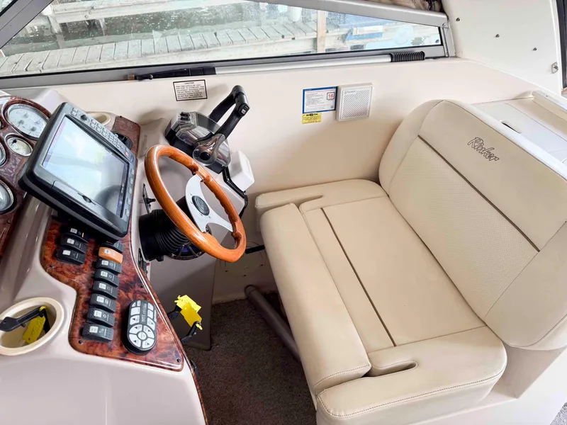 Slide: The Image of 2004 Rinker Fiesta Vee 290 helm with beige seating and modern controls. - 19