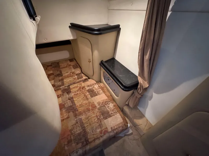 Slide: The Image of 2004 Rinker Fiesta Vee 290 cabin interior with bed and storage. - 22