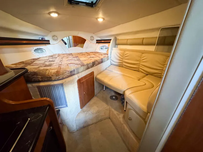 Slide: The Image of 2004 Rinker Fiesta Vee 290 cabin interior with bed and seating area. - 24
