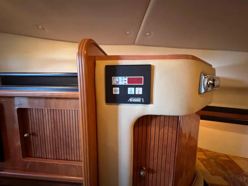 Slide: The Image of 2004 Rinker Fiesta Vee 290 interior with control panel and wooden cabinetry. - 26