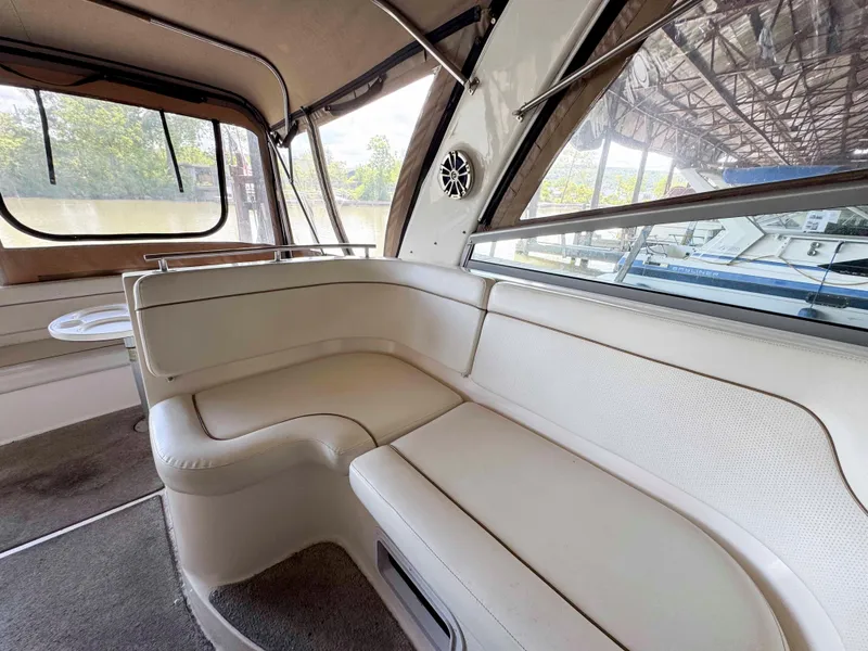 Slide: The Image of 2004 Rinker Fiesta Vee 290 interior with beige seating and large windows. - 9