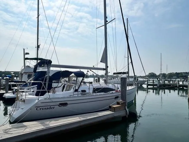 Slide: The Image of 2015 Catalina 315 sailboat docked at marina under a partly cloudy sky. - 2