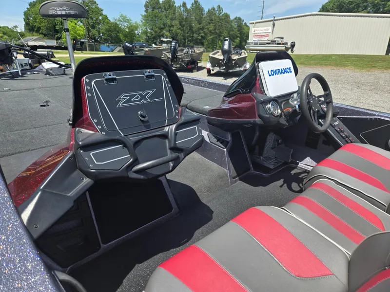 Slide: The Image of 2018 Skeeter ZX 250 boat interior with red and gray seating, steering wheel, and Lowrance display. - 12