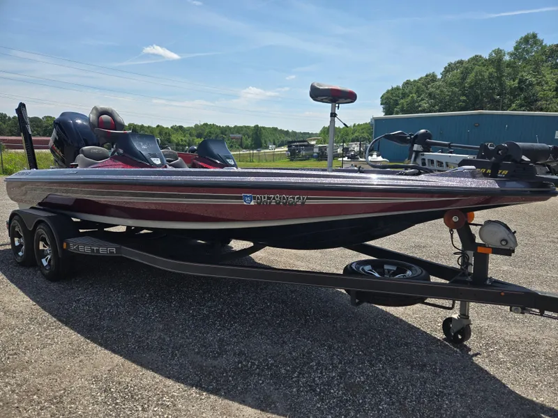 Slide: The Image of 2018 Skeeter ZX 250 bass boat on trailer, parked outdoors under clear sky. - 2