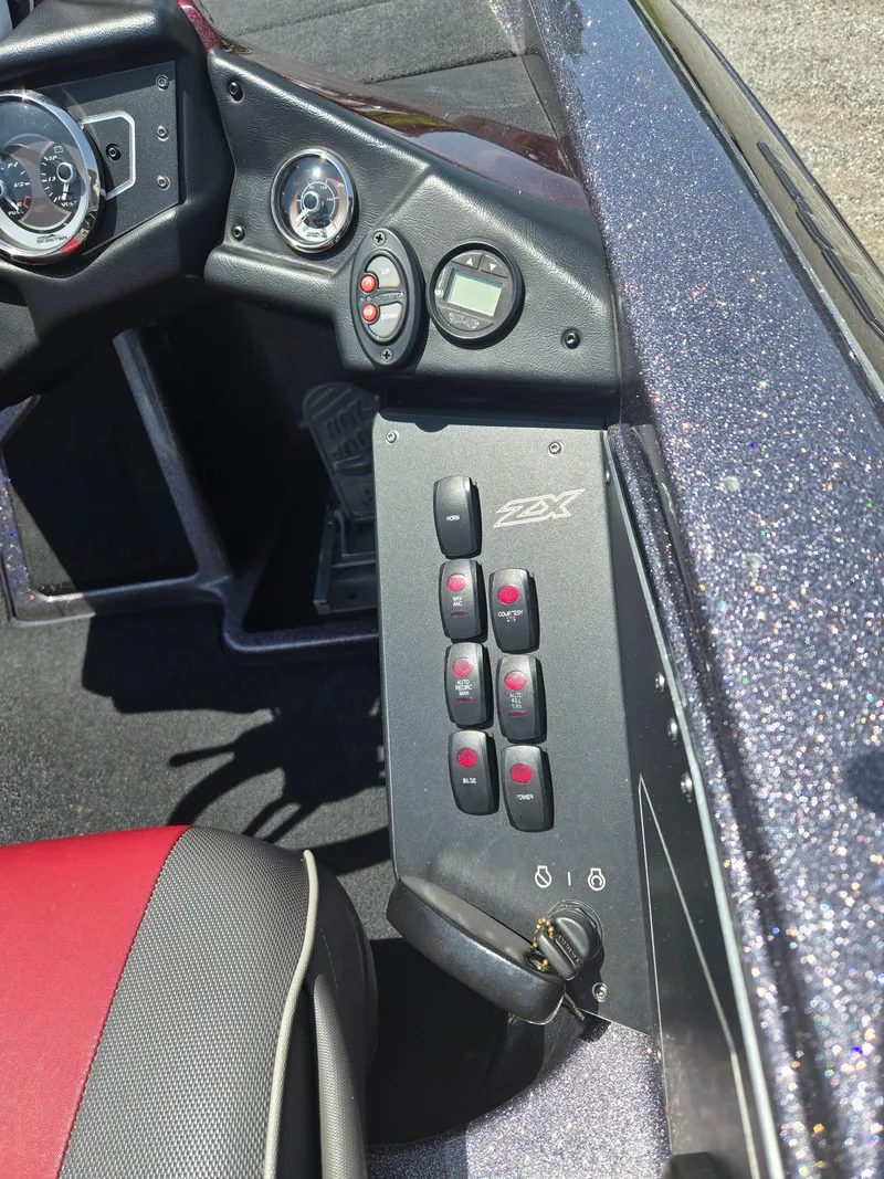 Slide: The Image of Control panel of a 2018 Skeeter ZX 250 boat with switches and gauges. - 9