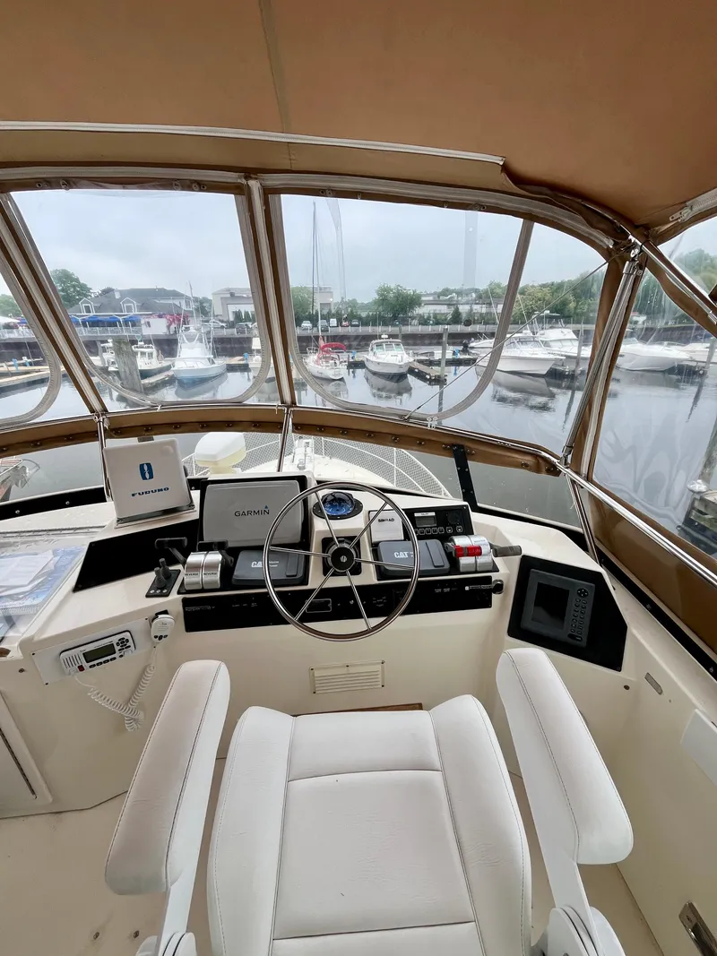 Slide: The Image of Interior view of 1996 Sabreline 43 Motoryacht helm with marina in background. - 11