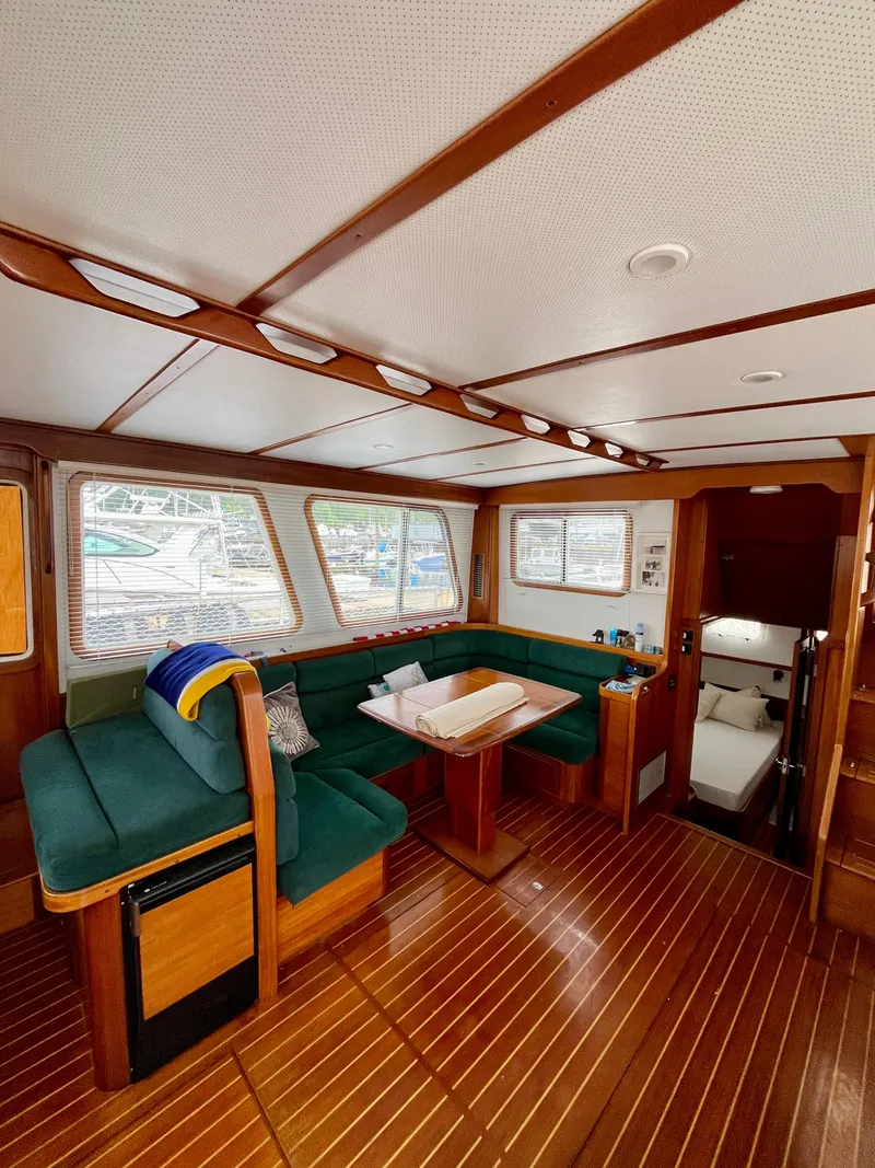 Slide: The Image of Interior of 1996 Sabreline 43 Motoryacht with green seating and wooden flooring. - 12