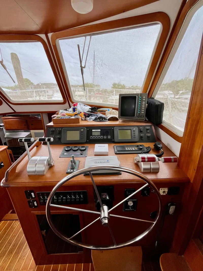 Slide: The Image of 1996 Sabreline 43 Motoryacht helm with steering wheel, navigation instruments, and wooden interior. - 16