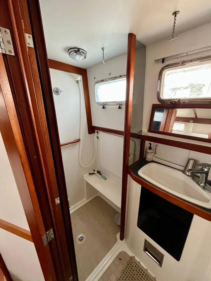 Slide: The Image of 1996 Sabreline 43 Motoryacht bathroom with shower, sink, and wooden accents. - 25