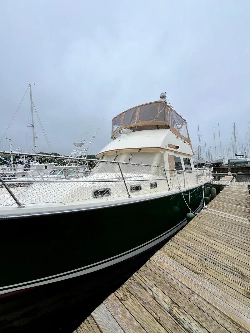 Slide: The Image of 1996 Sabreline 43 Motoryacht docked at a marina on a cloudy day. - 4