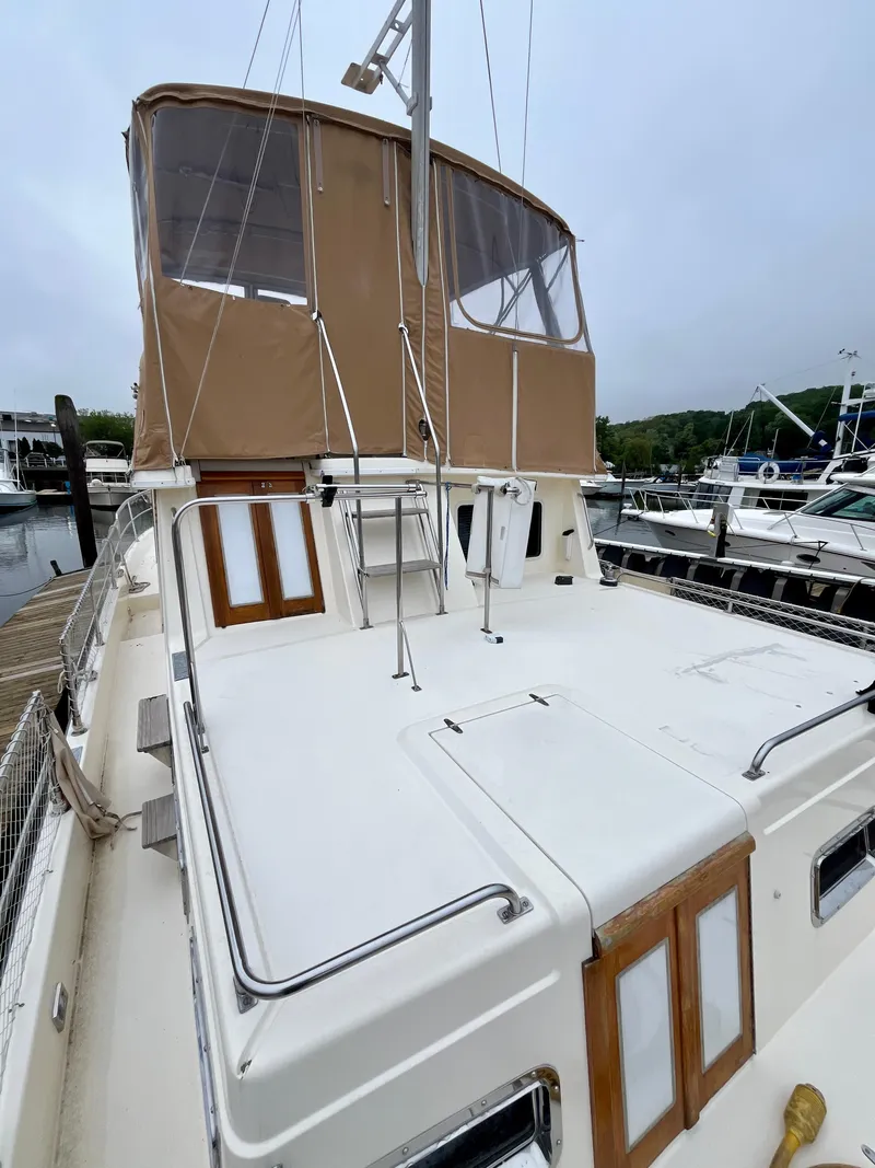 Slide: The Image of 1996 Sabreline 43 Motoryacht with tan canopy, docked at marina. - 7