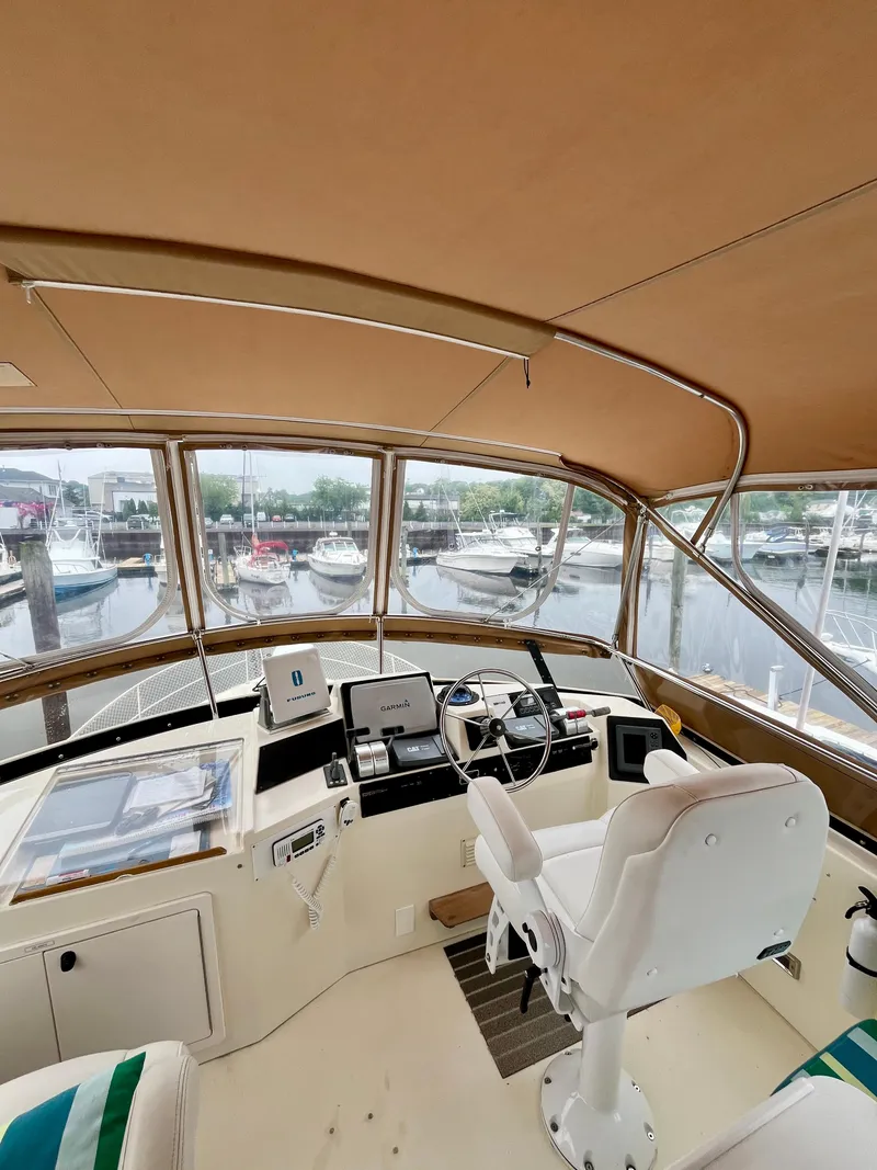 Slide: The Image of Interior view of 1996 Sabreline 43 Motoryacht helm with marina background. - 8