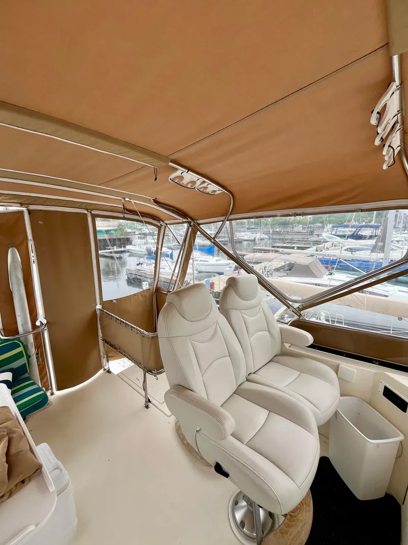 Slide: The Image of 1996 Sabreline 43 Motoryacht interior with plush seating and marina view. - 9