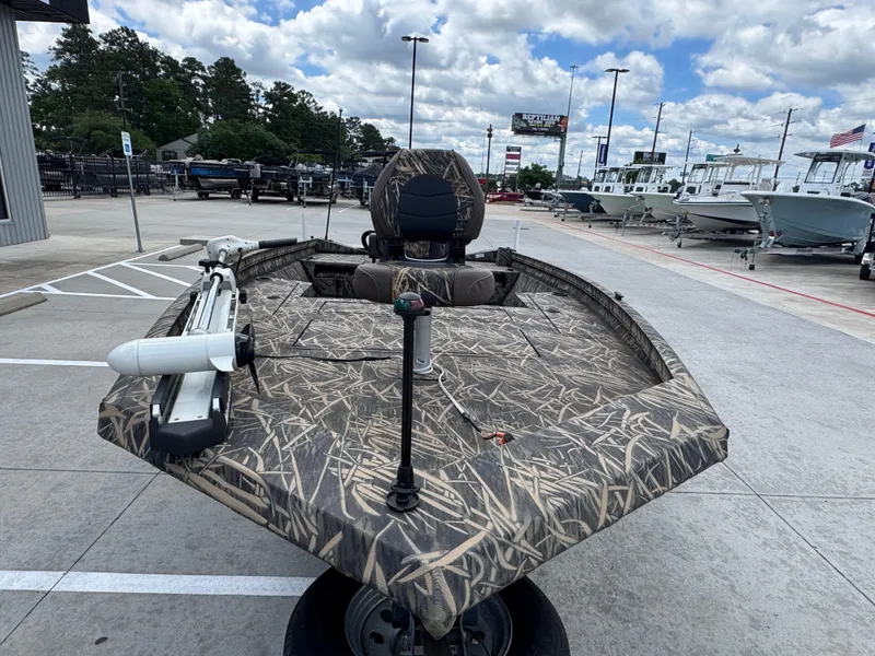 Slide: The Image of 2016 Crestliner 2000 Bay boat with camouflage design, displayed outdoors under a cloudy sky. - 10
