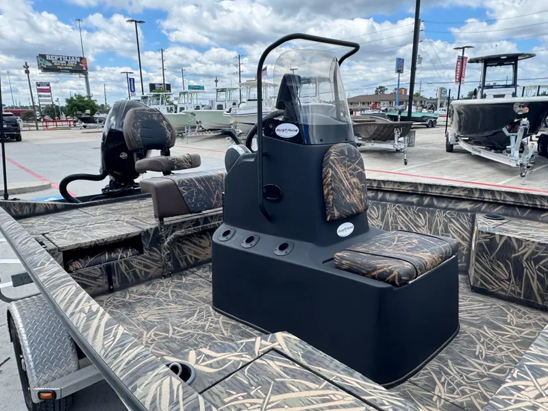 Slide: The Image of 2016 Crestliner 2000 Bay boat with camouflage interior, parked outdoors under cloudy sky. - 11