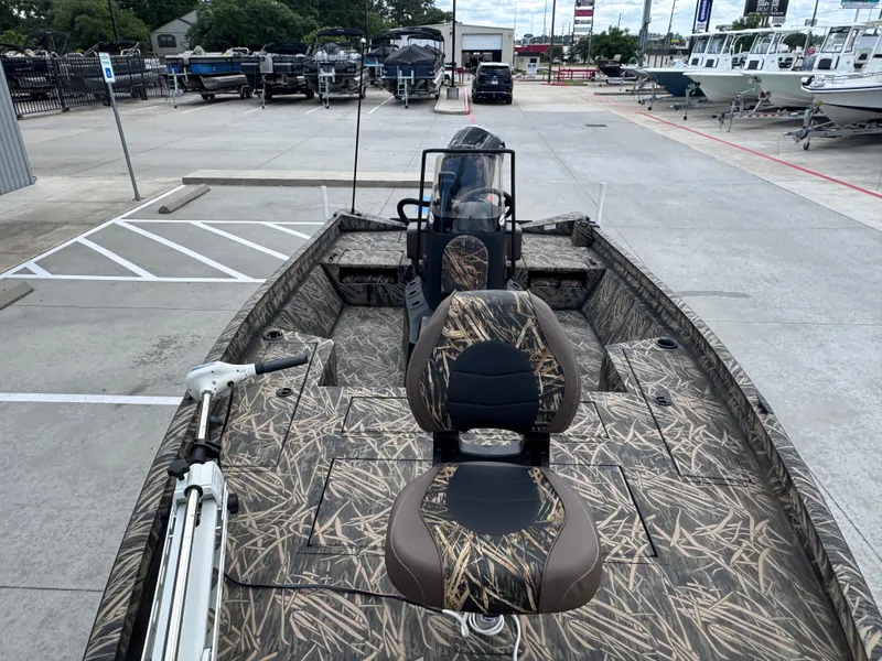 Slide: The Image of 2016 Crestliner 2000 Bay boat with camouflage interior, parked in a marina lot. - 12