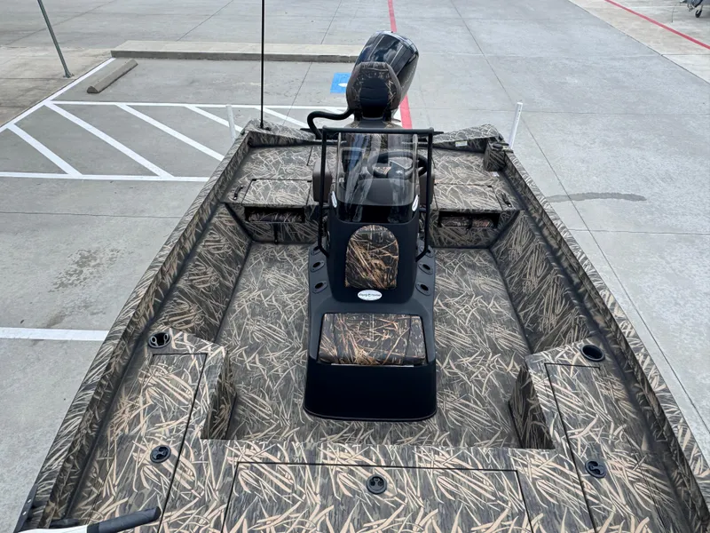 Slide: The Image of 2016 Crestliner 2000 Bay boat with camouflage interior, parked on concrete surface. - 13