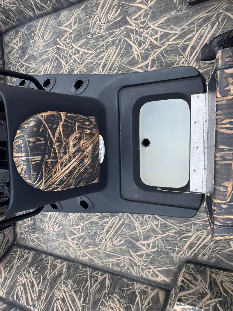 Slide: The Image of 2016 Crestliner 2000 Bay boat interior with camouflage seating and storage compartment. - 14