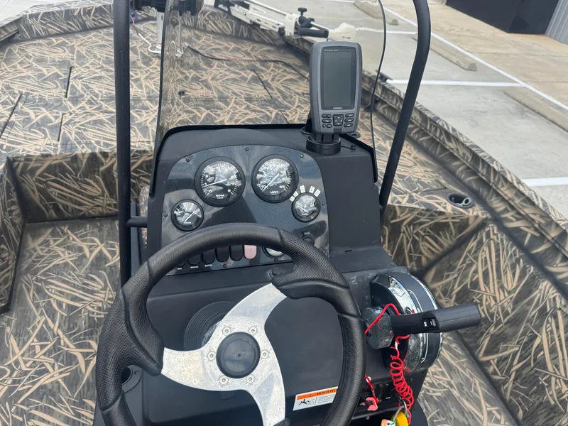 Slide: The Image of 2016 Crestliner 2000 Bay boat dashboard with steering wheel and navigation equipment. - 16