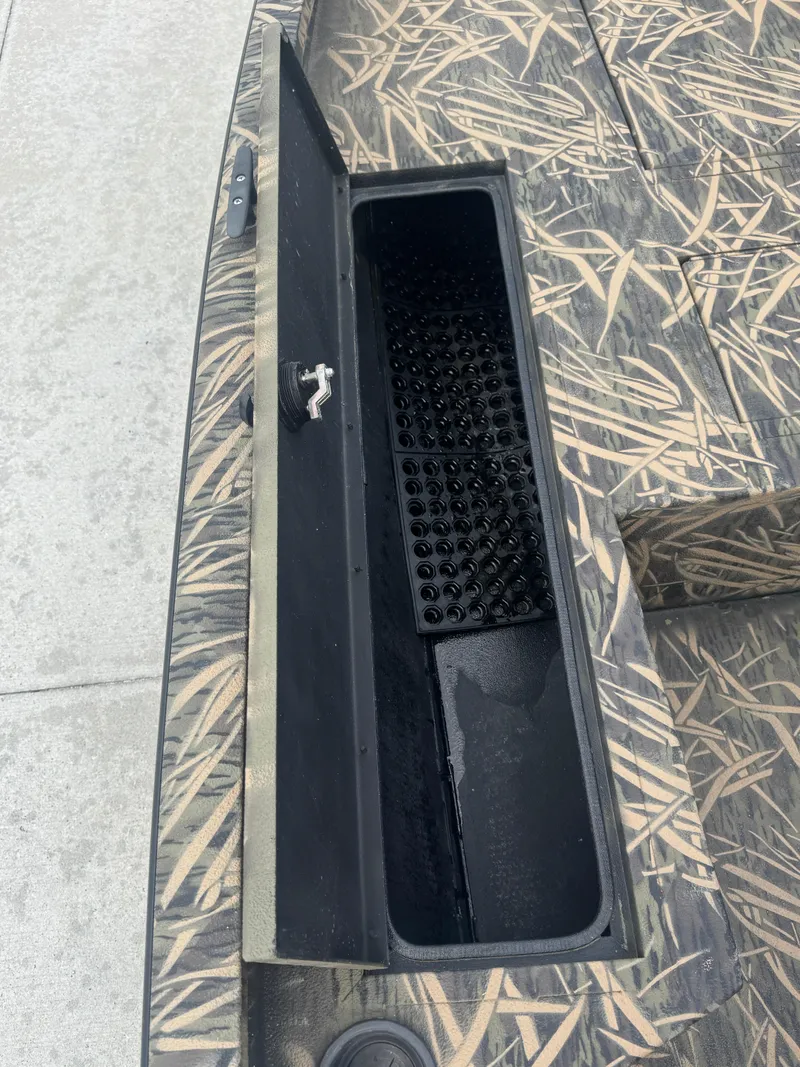 Slide: The Image of Open storage compartment on 2016 Crestliner 2000 Bay boat with camouflage pattern. - 17