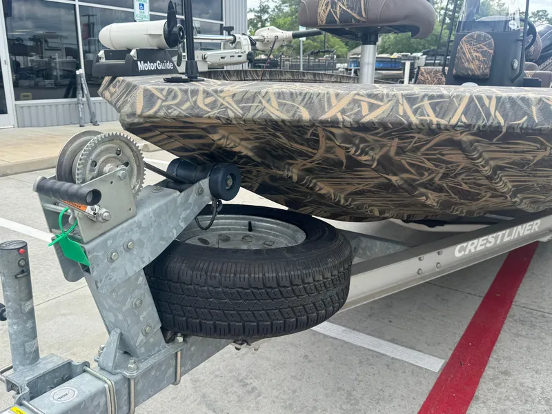 Slide: The Image of 2016 Crestliner 2000 Bay boat on trailer with camo design and spare tire. - 21