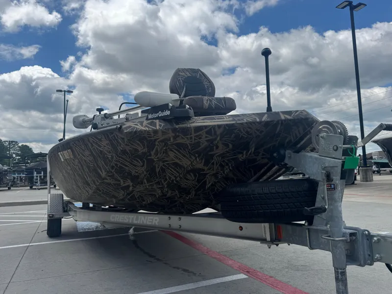 Slide: The Image of 2016 Crestliner 2000 Bay boat on trailer, camo design, under cloudy sky. - 9