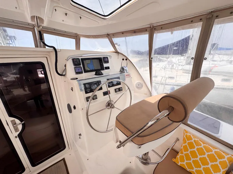 Slide: The Image of Helm of 2007 Leopard 43 catamaran with steering wheel, navigation controls, and cushioned seating. - 13