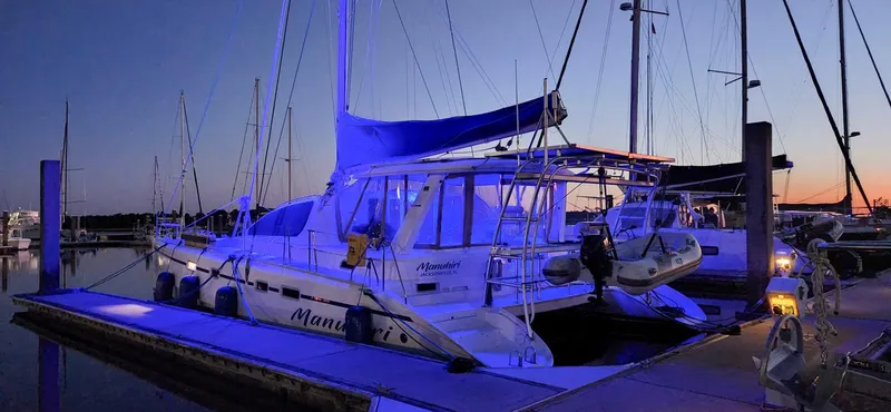 Slide: The Image of Leopard 43 catamaran docked at sunset, illuminated with blue lights, 2007 model. - 2