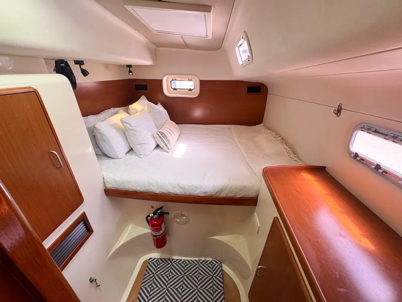 Slide: The Image of Cozy cabin interior of 2007 Leopard 43 yacht with bed, pillows, and wooden accents. - 29