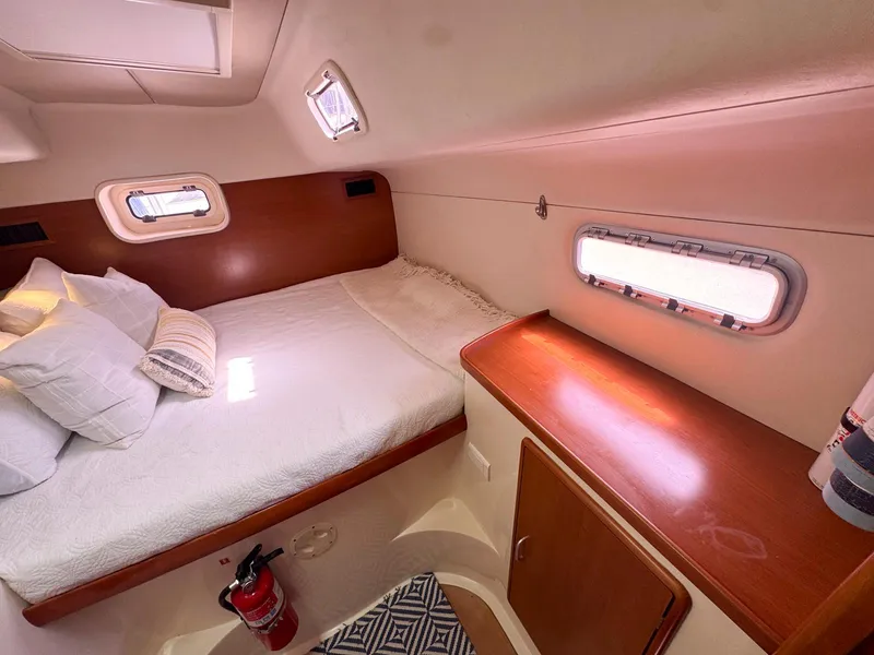 Slide: The Image of Cozy cabin interior of a 2007 Leopard 43 yacht with bed and porthole windows. - 30