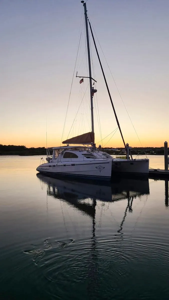 Slide: The Image of 2007 Leopard 43 catamaran docked at sunset, reflecting on calm water. - 7